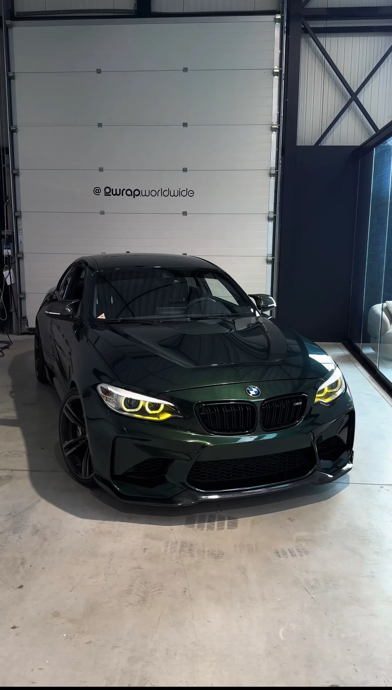 BMW M2 in Midnight Green Metallic in de hal, recht van voren