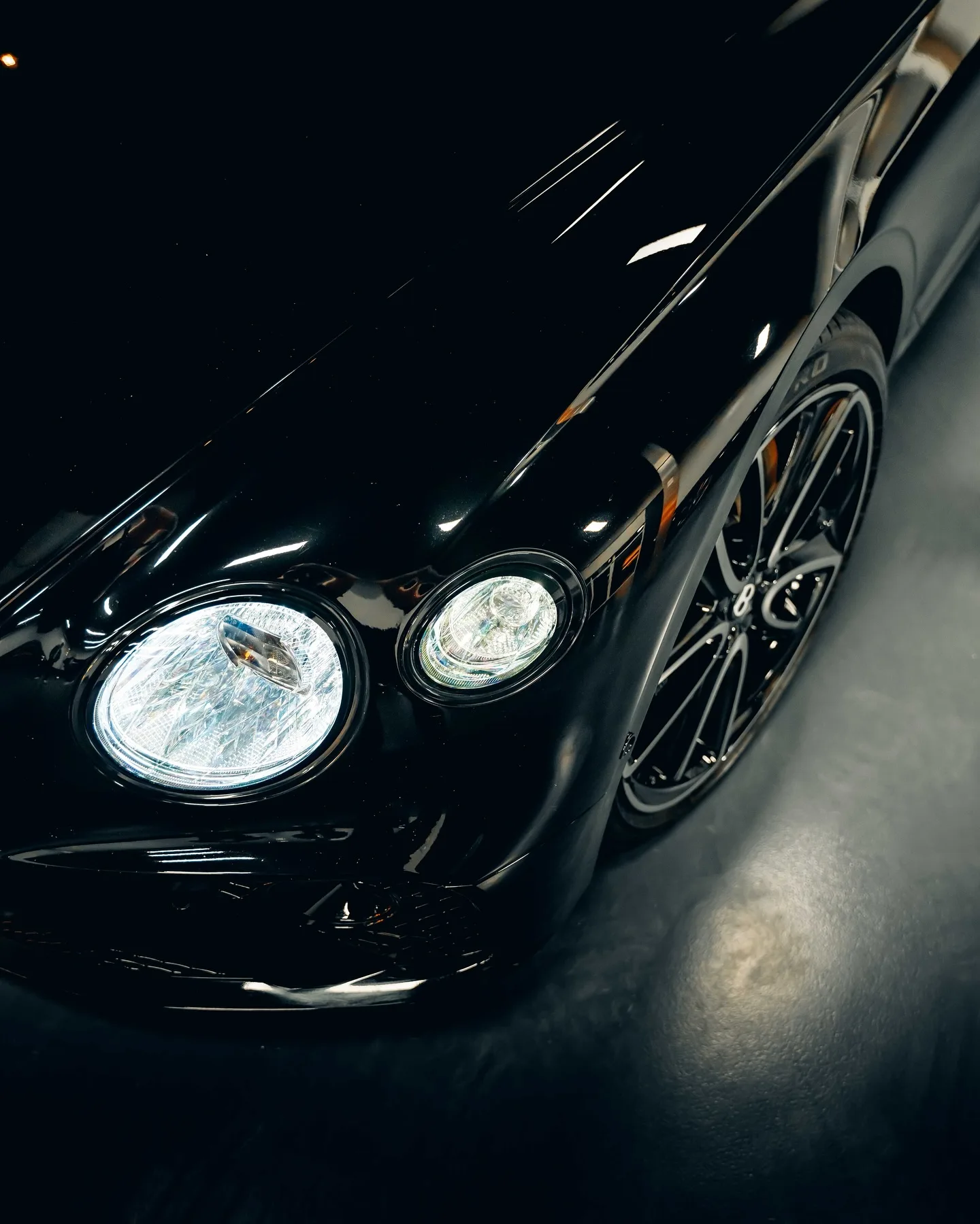 Koplampen en glanzend zwarte neus van de Bentley Continental GT
