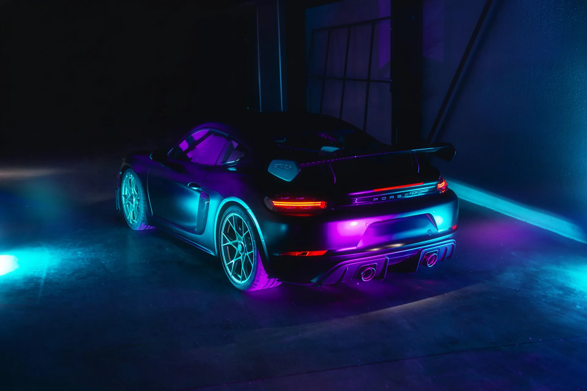 Porsche GT4 RS van achteren in blauw en paars neonlicht