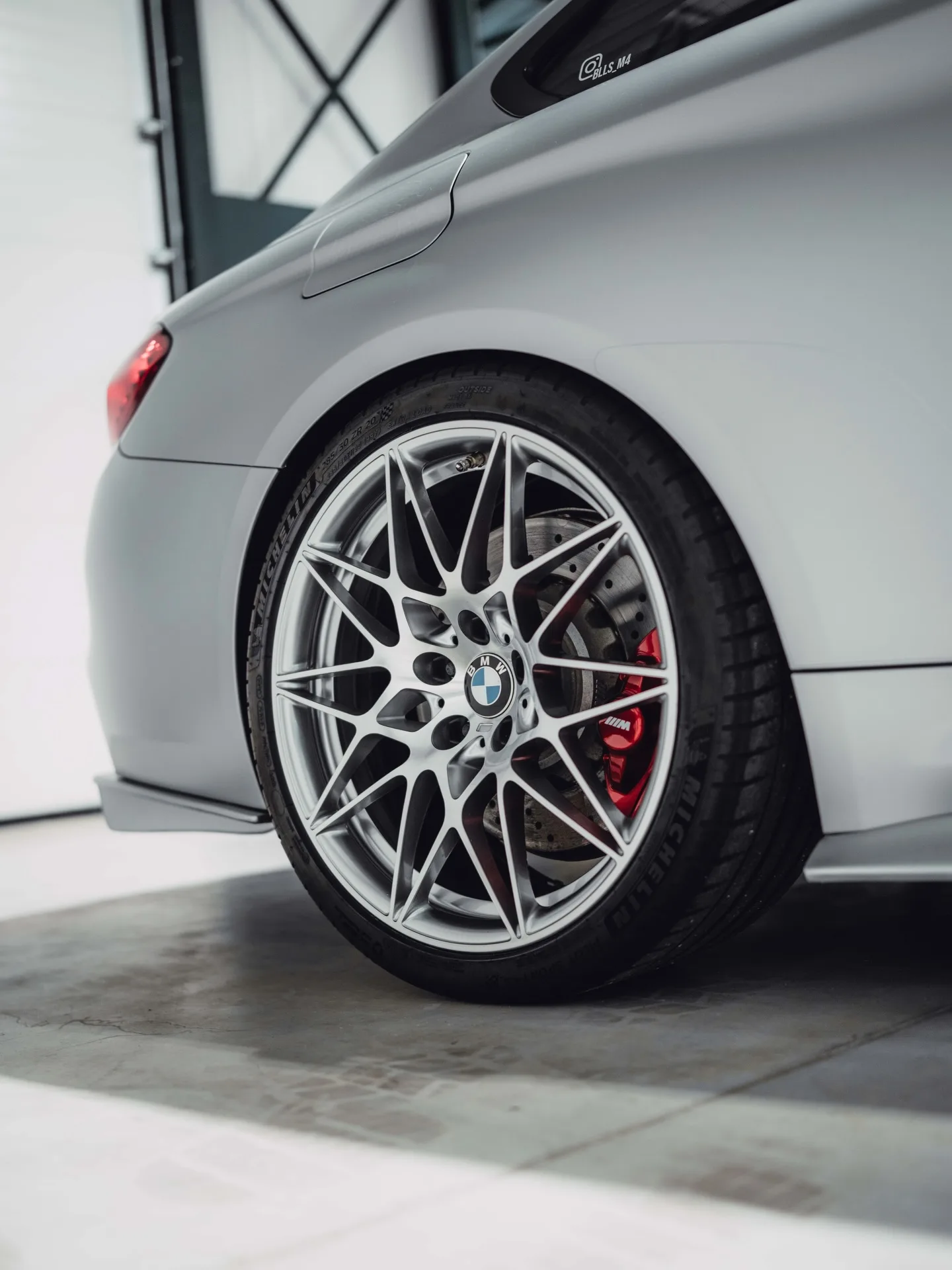 Zilveren velg en achterscherm van de BMW M4 in Satin White Aluminium