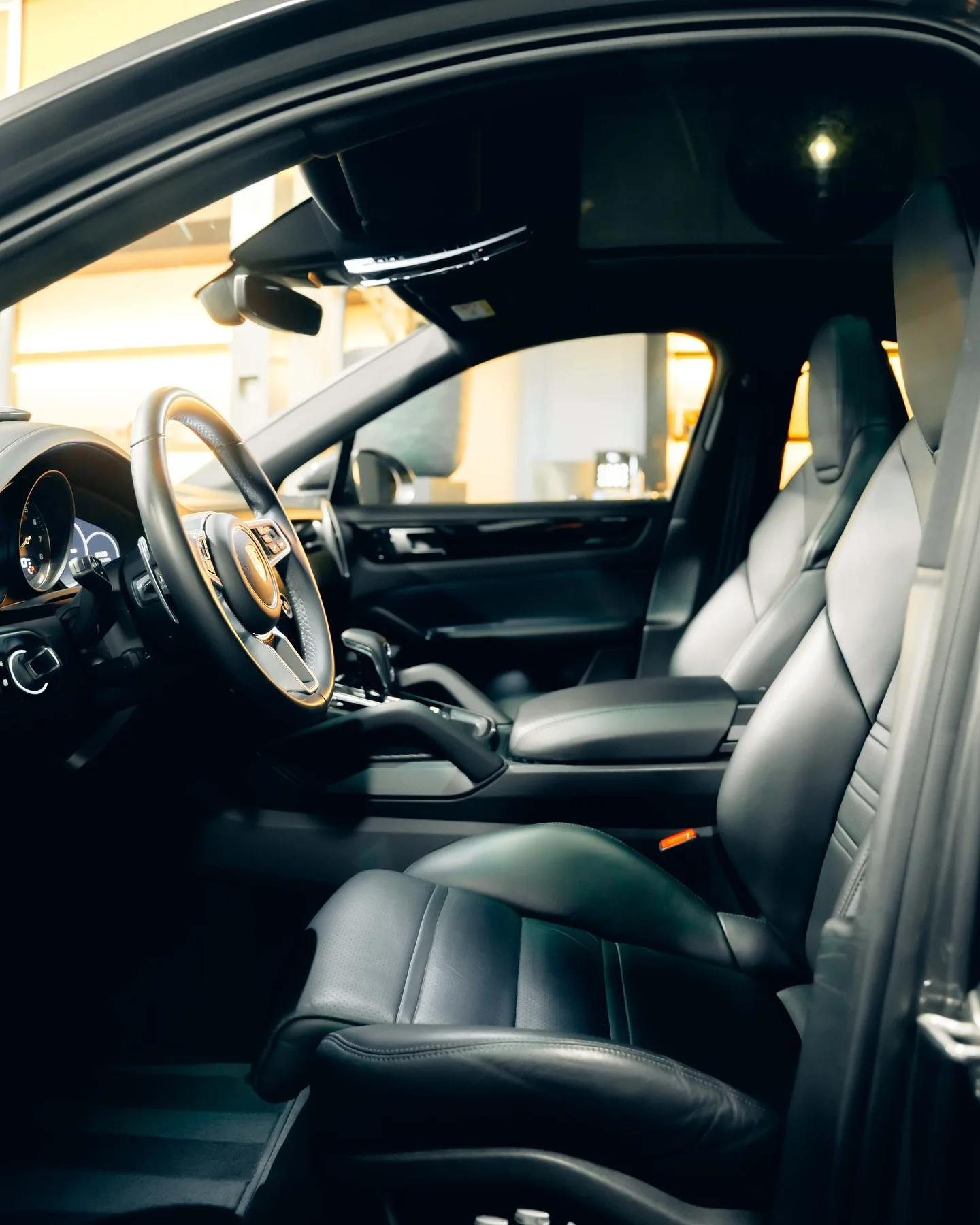 Zwart lederen interieur van de Porsche Cayenne Coupé door het open portier