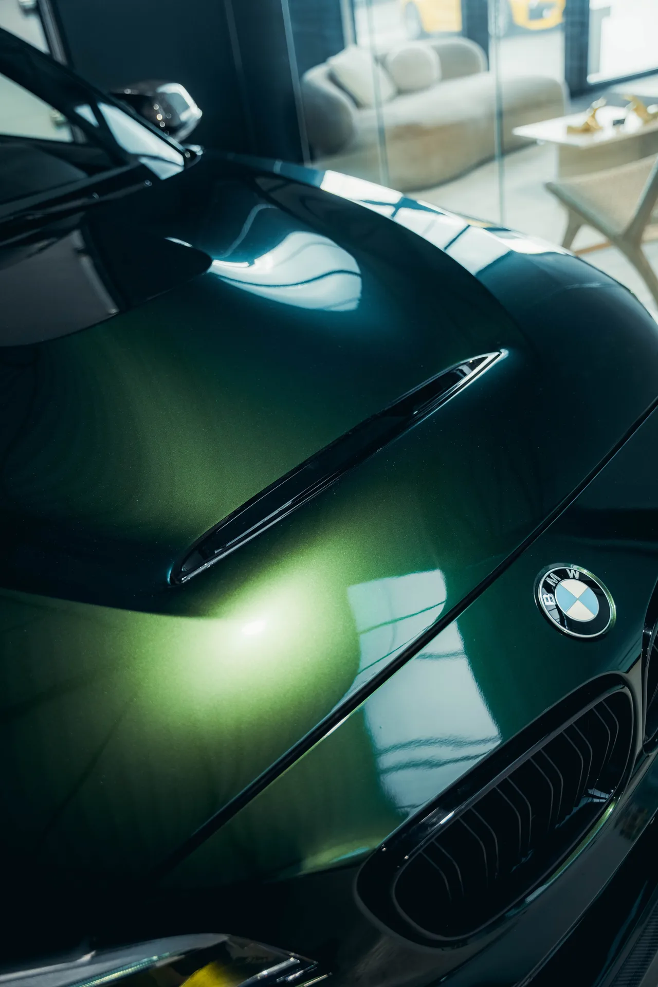 Motorkap van een BMW M5 Touring in diepgroen, met het BMW embleem en de nieren