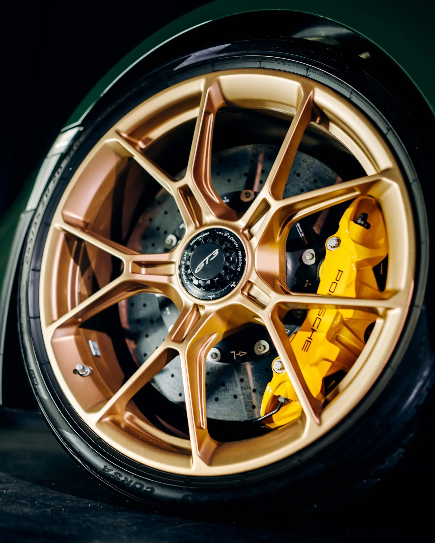 Gouden velg met gele remklauw van de Porsche 992 GT3, van dichtbij