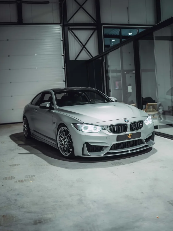 BMW M4 in Satin White Aluminium in de hal, schuin van voren