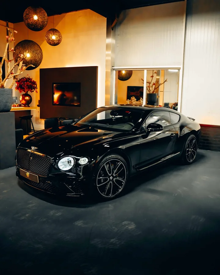 Zwarte Bentley Continental GT in de studio, schuin van voren