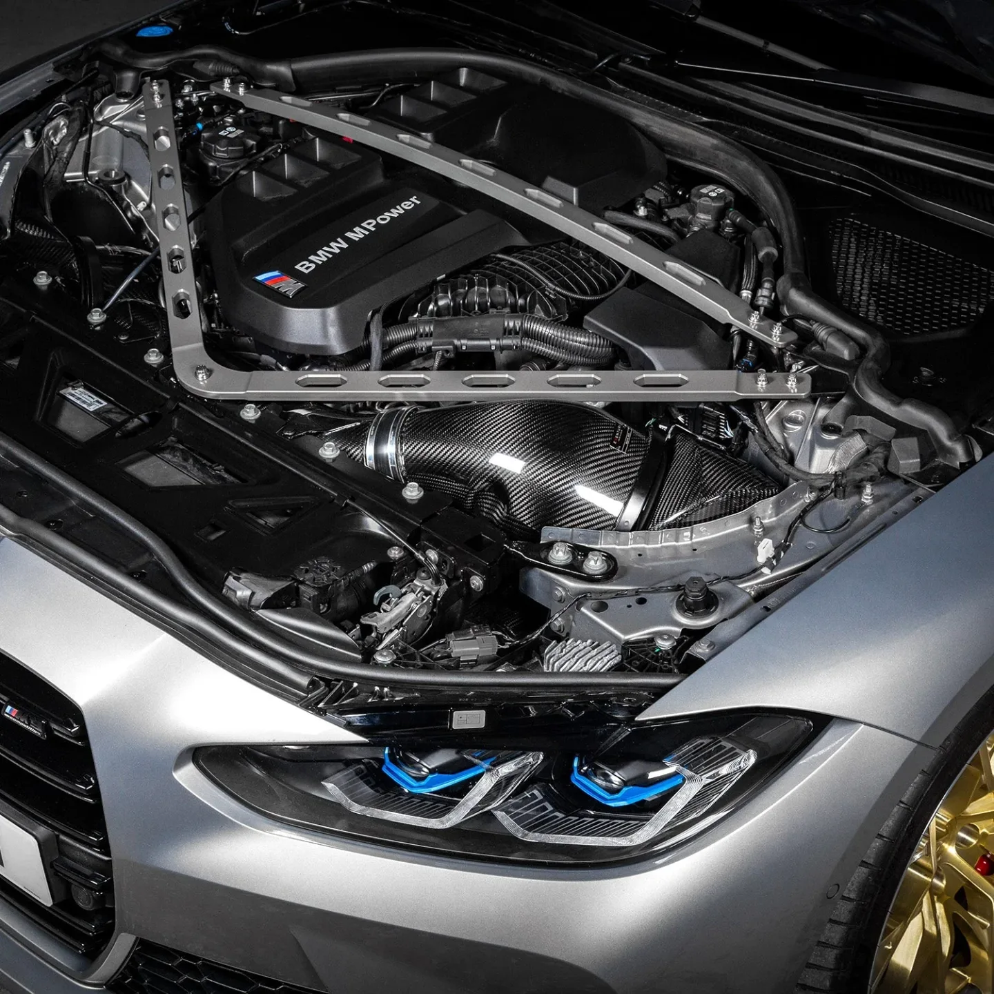 Carbon luchtinlaatsysteem in de motorruimte van een BMW M